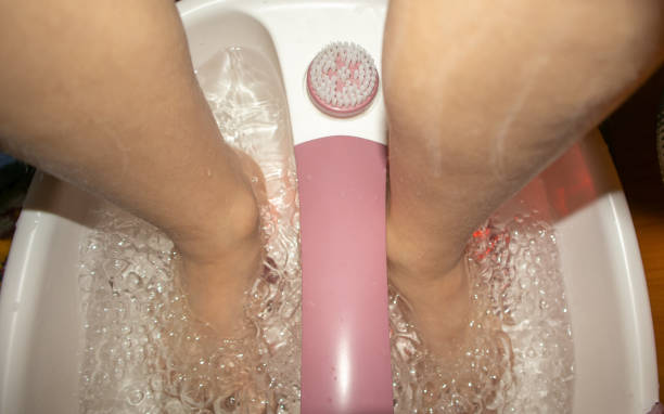 zbliżenie stóp w wannie za pomocą wibrującego masażera stóp. elektryczna kąpiel do masażu stóp i bąbelki wody. pedicure i pielęgnacja stóp - gurgling zdjęcia i obrazy z banku zdjęć