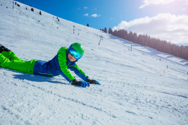 istock Boy with snowboard lay on the ski slope close-up image 1394711698