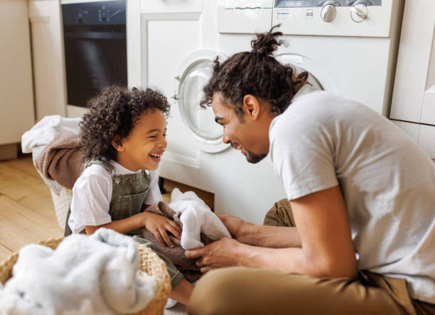 istock Son helping dad to load washing machine 1394718730