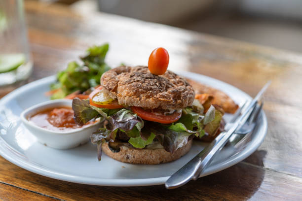 Vegetarian burger with falafel and vegetables salad, tomato, champignon and tofu cheese on plate with sweet potato