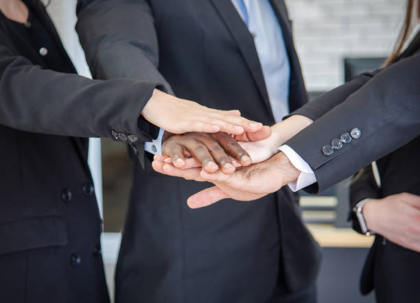 istock Close up young business people putting their hands together. Stack of hands. Unity and teamwork concept. 1394724650