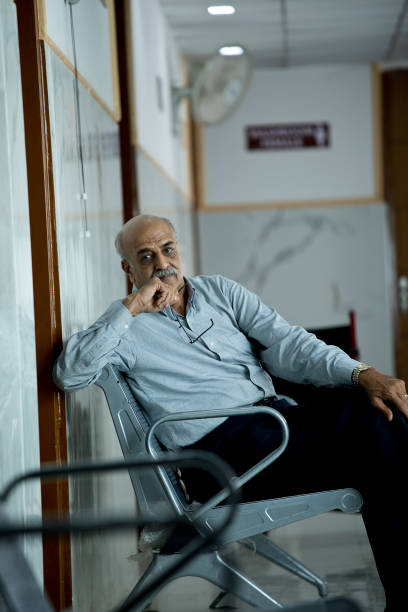 istock Man sitting in hospital corridor 1394726280