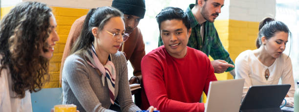 istock Horizontal banner or header with young co-workers multiethnic team planning a new startup - People working on a new project in creative coworking office - Bright filter with focus on asian man face 1394727483