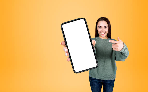 istock Woman pointing at phone mockup display on bright background 1394731287