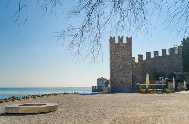 Sirmione, Italy -  March 9, 2022: The square of the beach of the Muses with the walls of the old town in the background