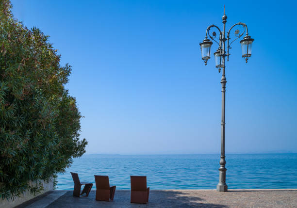 Italy, Lazise, seats and street lantern on the lake shore