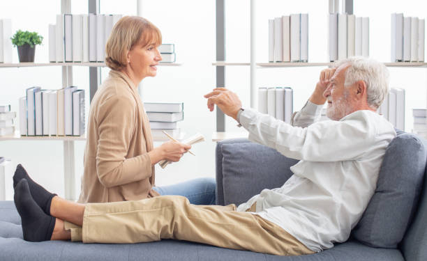 mujer mayor que apoya a su marido enfermo acostado en un sofá. jubilado anciano anciano esposo enfermedad con esposa grave cuidar en casa. tratamiento de emergencia médica y protección del seguro de atención médica - human hand help pain heart attack fotografías e imágenes de stock