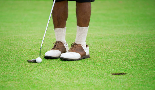 istock Male golfer putting on golf course 1394739849