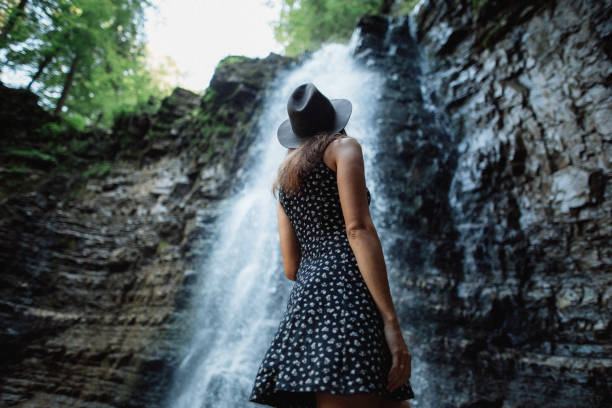 istock Woman looks at the waterfall 1394744091