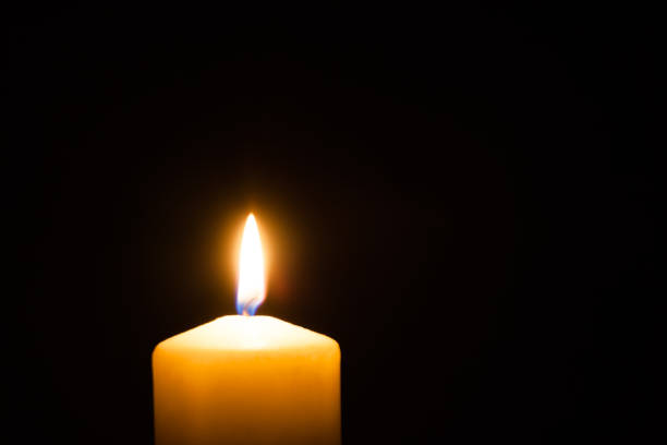 istock Memorial candle with flame in the dark 1394746627