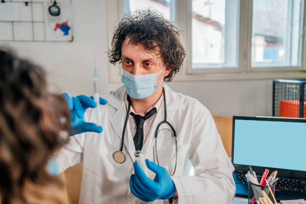 istock Male doctor vaccinating a patient 1394749218
