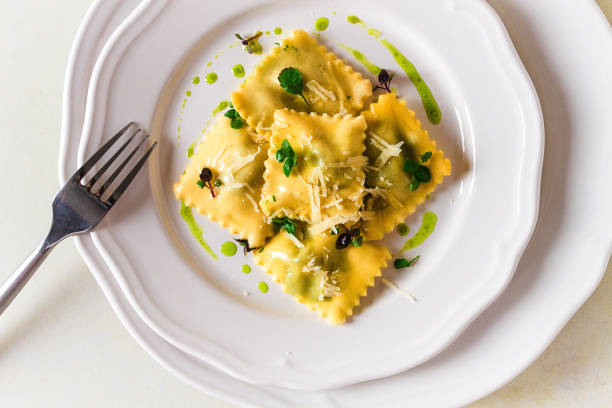 ravioli con spinaci e formaggio, salsa verde, su sfondo chiaro, messa a fuoco selettiva, niente persone, - edible mushroom mushroom ravioli basil foto e immagini stock