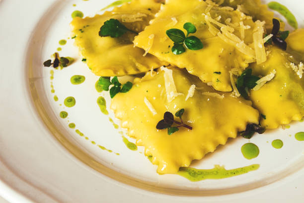 Ravioli with spinach and cheese, green sauce, on a light background, selective focus, no people,