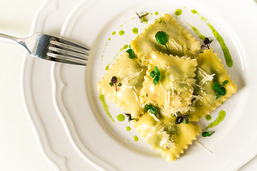 Ravioli with spinach and cheese, green sauce, on a light background, selective focus, no people,