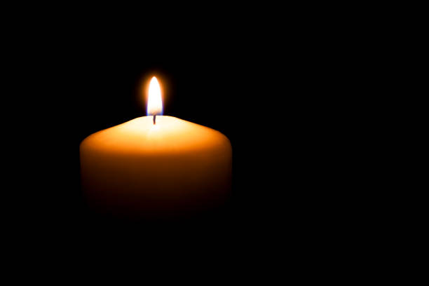 istock Memorial candle with flame in the dark 1394752179