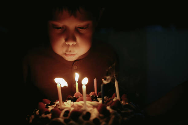 istock Cute caucasian boy blowing up candles pn birthday cake. Image with selective focus 1394752361