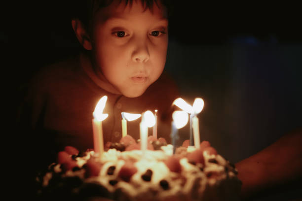 istock Cute caucasian boy blowing up candles pn birthday cake. Image with selective focus 1394752367