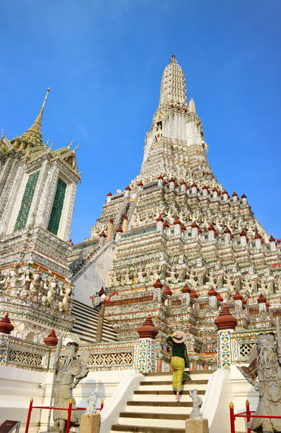 женщина, поднимающаяся к центральному шпилю под названием phraprang of wat arun (храм рассвета), одна из знаковых достопримечательностей бангкока, т� - thonburi стоковые фото и изображения