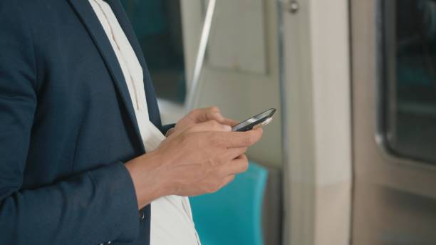 istock businessman standing on the seat using modern smartphone to internet checking news on electric train 1394752436