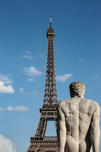 Stone statue of a man in front of the Eifel Tower, Paris, France