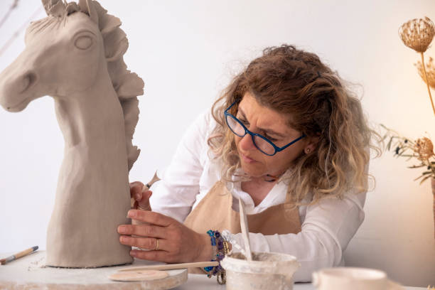 istock middle-aged making a horse sculpture in the workshop 1394757784