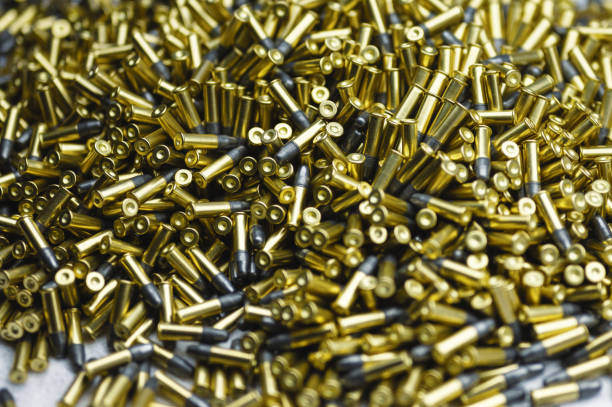 istock Small-caliber bullets on white table at production plant 1394758628