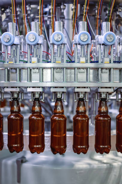 riempitrice automatica, un sacco di bottiglie di plastica riempite con birra - bottling plant brewery industry food foto e immagini stock