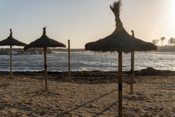 istock Straw umbrellas in a cove at sunset 1394758700
