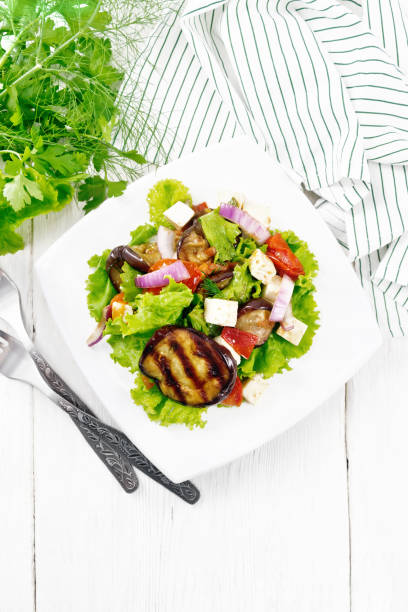 istock Salad of eggplant with cheese and tomatoes on white board top 1394758794