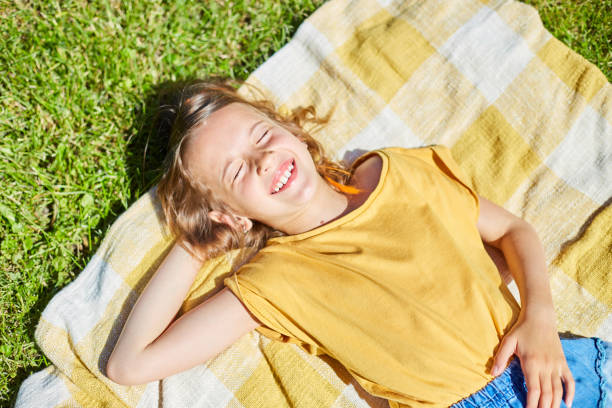 istock Child lying on the blanket, on the grass in the sun day 1394759263