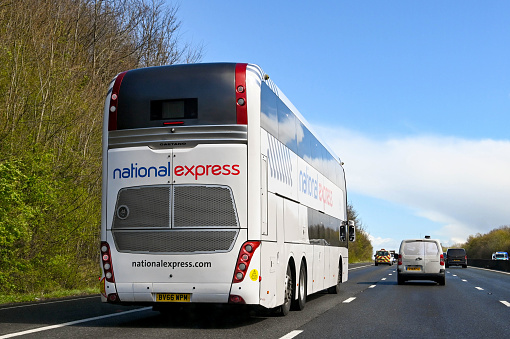 Bristol, England - April 2022: Rear view of a double decker express coach on the M4 motorway. The bus is operated by National Express.