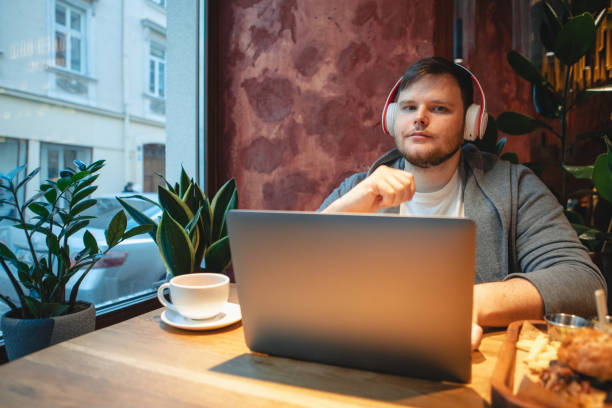 istock man freelancer working on laptop in cafe eating burger and drinking tea 1394763555