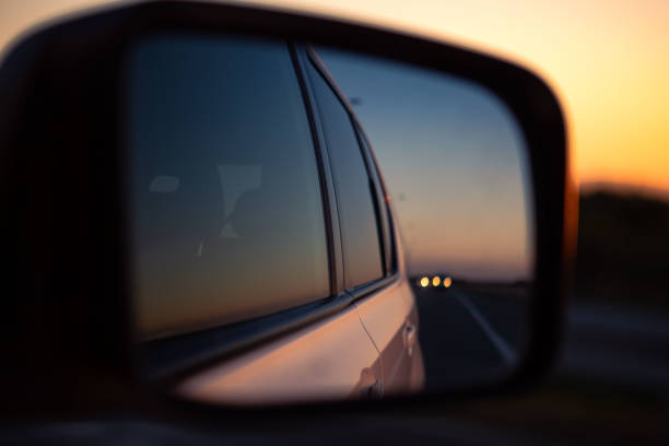 istock reflection in car rear mirror sunset on the road 1394763620
