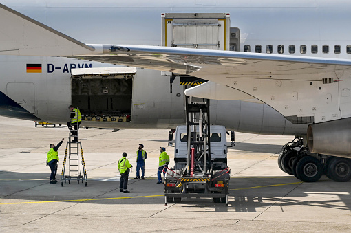 Frankfurt, Germany - April 2022: Airport workers checking the cargo hold of a Lufthansa Boeing 747 jet.