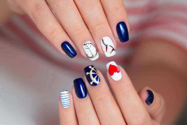 istock Female hands with manicure nails in marine style 1394763950