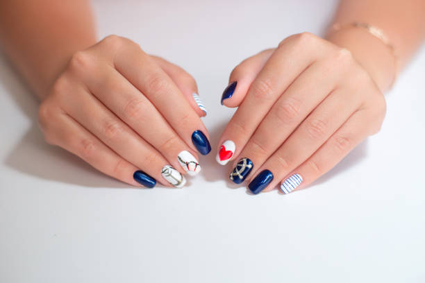 istock Female hands with manicure nails in marine style 1394763952