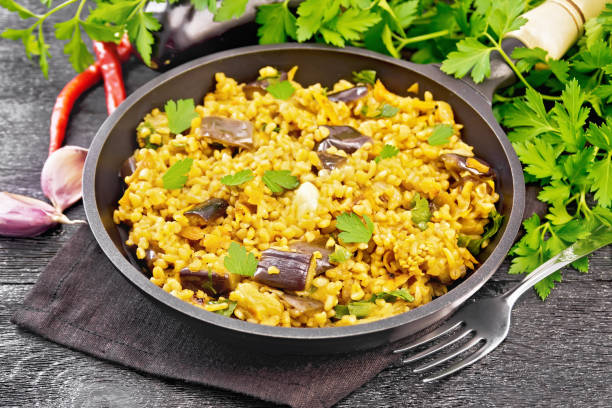istock Bulgur with eggplant in pan on dark board 1394764551