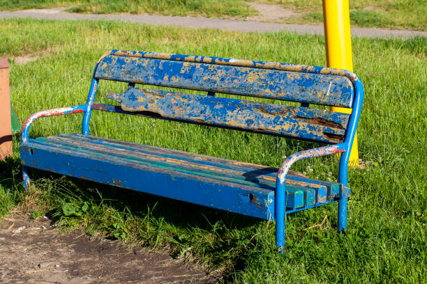 an old bench with stripped paint in the park, an old not repaired bench in the park
