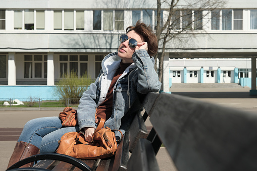 Woman wearing reflecting sunglasses is looking at the sky