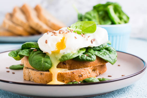 istock Appetizing sandwich with poached egg, spinach and flax seeds on a plate. Flexetarian Diet. Close-up 1394768923