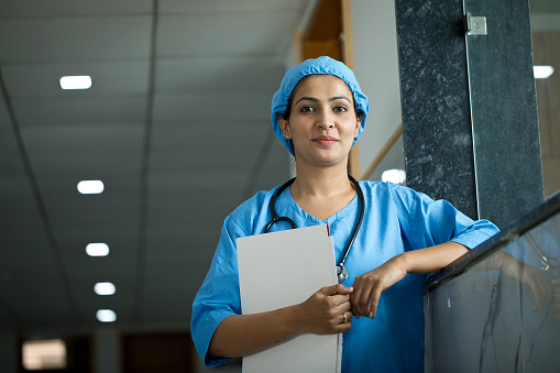 Portrait of smiling female nurse with a medical file at hospital corridor
