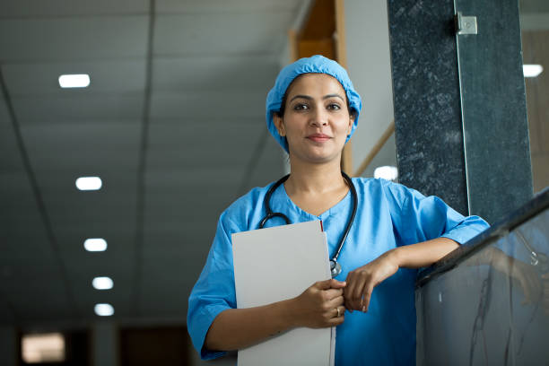 Nurse with medical file at hospital Portrait of smiling female nurse with a medical file at hospital corridor india hospital stock pictures, royalty-free photos & images