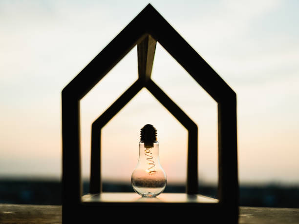 Light bulb with wood house on the table, a symbol for construction, Creative light bulb idea, power energy or business idea concept ecology, loan, mortgage, property or home.