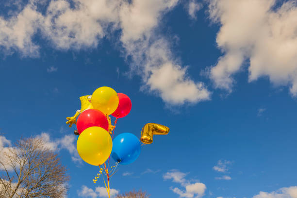 View of festive balloons for child developing in  wind against blue sky with white clouds. Sweden