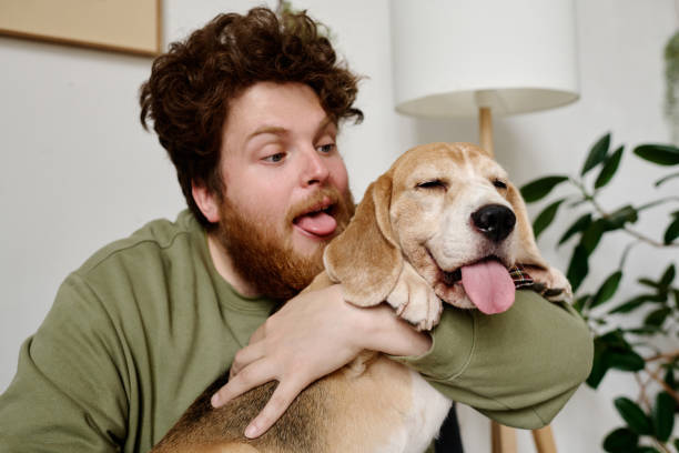 istock Man fooling around with his dog 1394772180