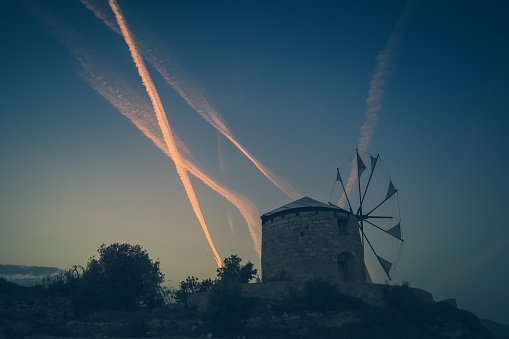 Windmills in Chios Island with airplane trails at the background