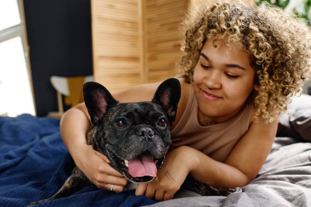 istock Young woman relaxing in bed with dog 1394774813