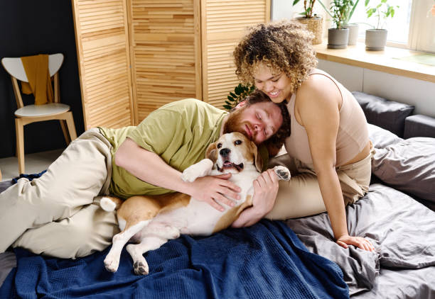 istock Couple with dog relaxing on bed 1394774901