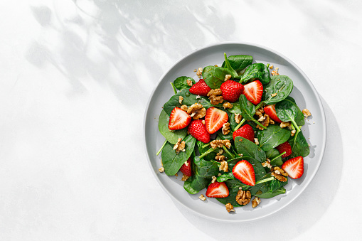 Strawberry and spinach salad with walnuts, top view