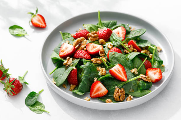istock Strawberry and spinach salad with walnuts, top view 1394778242